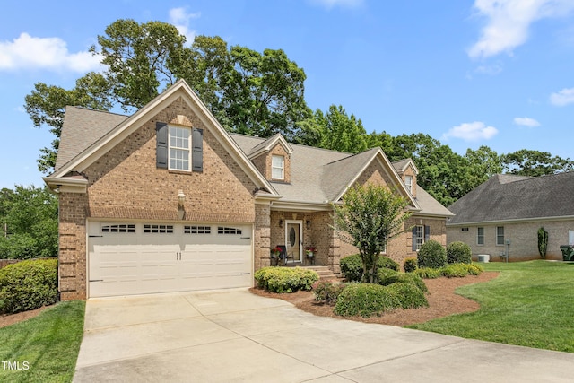 412 Whitt Ave, Burlington, NC 27215 - traditional-style house featuring concrete driveway, brick siding, a front yard, and roof with shingles