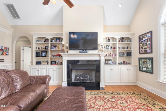 412 Whitt Ave, Burlington, NC 27215 - living area featuring lofted ceiling, ceiling fan, light wood-style flooring, arched walkways, and a fireplace with flush hearth