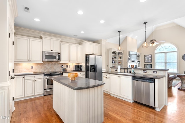 412 Whitt Ave, Burlington, NC 27215 - kitchen featuring appliances with stainless steel finishes, an island with sink, light wood-style flooring, a ceiling fan, and lofted ceiling