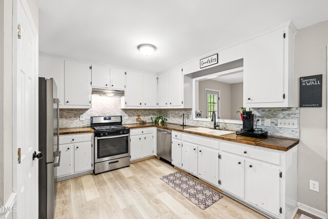 2809 Titleist Dr, Hillsborough, NC 27278 - kitchen with stainless steel appliances, under cabinet range hood, decorative backsplash, and white cabinets