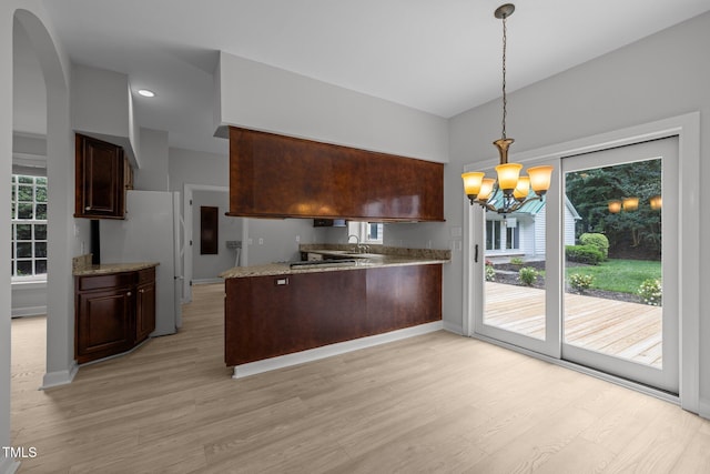 300 Oak Ridge Dr, Hillsborough, NC 27278 - kitchen with light wood-type flooring, a peninsula, a chandelier, and dark brown cabinetry