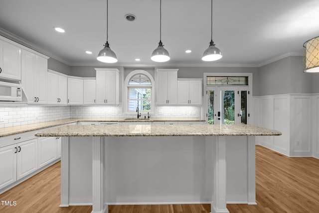 300 Oak Ridge Dr, Hillsborough, NC 27278 - kitchen with white microwave, white cabinetry, ornamental molding, a center island, and decorative backsplash