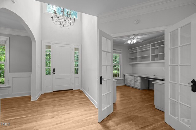 300 Oak Ridge Dr, Hillsborough, NC 27278 - entryway with crown molding, arched walkways, light wood-style flooring, built in study area, and a chandelier