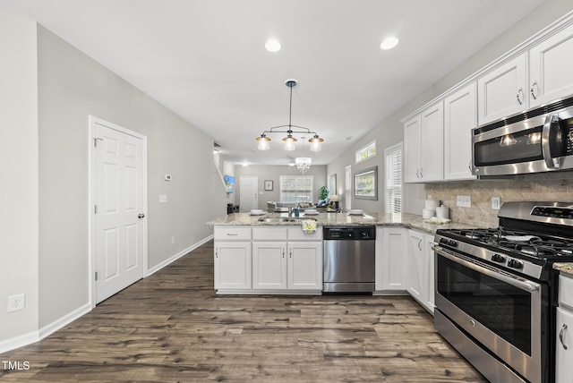 1625 Main Divide Dr, Wake Forest, NC 27587 - kitchen with appliances with stainless steel finishes, a peninsula, white cabinets, dark wood finished floors, and recessed lighting