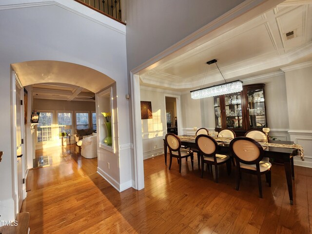 502 Willowmere Ct, Cary, NC 27513 - dining room featuring hardwood / wood-style flooring, arched walkways, ornamental molding, a decorative wall, and coffered ceiling