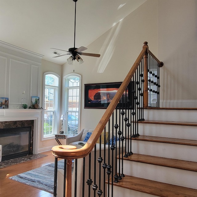 502 Willowmere Ct, Cary, NC 27513 - staircase featuring wood finished floors, a fireplace, a ceiling fan, and vaulted ceiling
