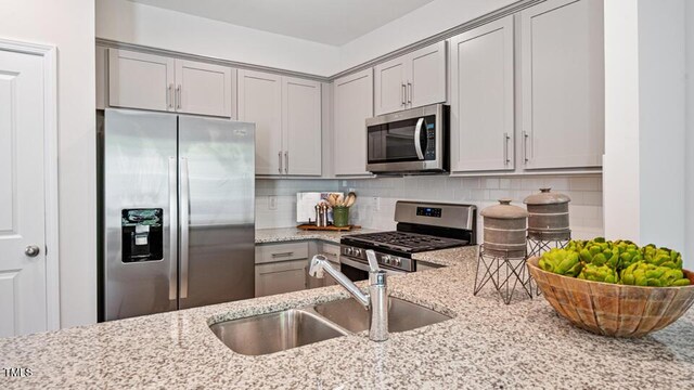 419 Belgian Red Way, Wake Forest, NC 27587 - kitchen with appliances with stainless steel finishes, gray cabinets, light stone countertops, and decorative backsplash