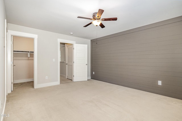 442 Granite Mill Blvd, Chapel Hill, NC 27516 - unfurnished bedroom with light carpet, a spacious closet, wood walls, a ceiling fan, and a closet