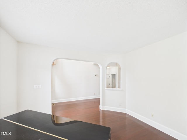 7501 Montibillo Pkwy, Durham, NC 27713 - unfurnished room featuring dark wood-style flooring and arched walkways
