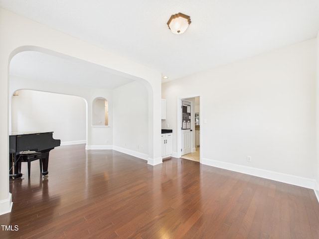 7501 Montibillo Pkwy, Durham, NC 27713 - unfurnished living room featuring arched walkways and wood finished floors