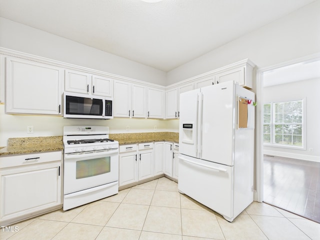 7501 Montibillo Pkwy, Durham, NC 27713 - kitchen with white appliances, white cabinets, light stone countertops, and light tile patterned floors