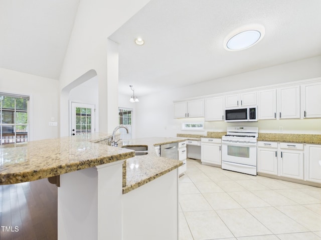7501 Montibillo Pkwy, Durham, NC 27713 - kitchen with white appliances, white cabinetry, light stone countertops, lofted ceiling, and recessed lighting