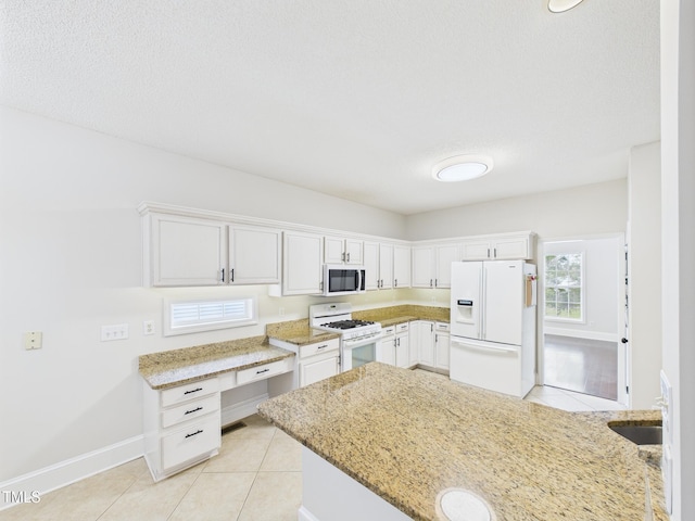 7501 Montibillo Pkwy, Durham, NC 27713 - kitchen featuring white appliances, light tile patterned flooring, white cabinetry, and light stone countertops