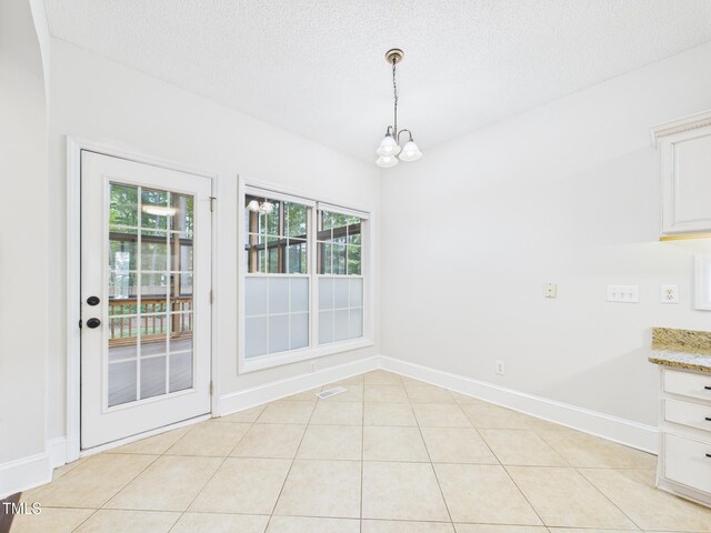 7501 Montibillo Pkwy, Durham, NC 27713 - unfurnished dining area featuring a chandelier, a textured ceiling, and light tile patterned floors