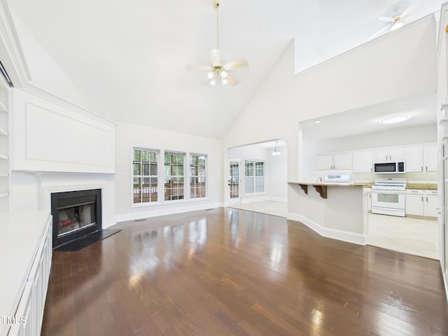 7501 Montibillo Pkwy, Durham, NC 27713 - unfurnished living room featuring ceiling fan, light wood-style flooring, high vaulted ceiling, and a fireplace