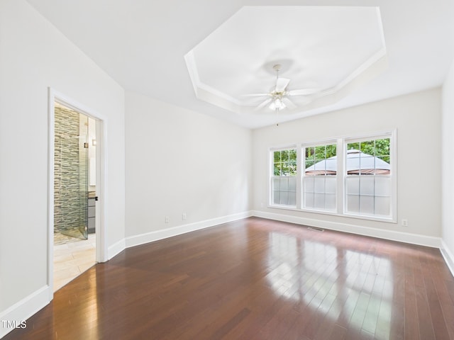 7501 Montibillo Pkwy, Durham, NC 27713 - unfurnished room with a raised ceiling, dark wood-style flooring, and a ceiling fan
