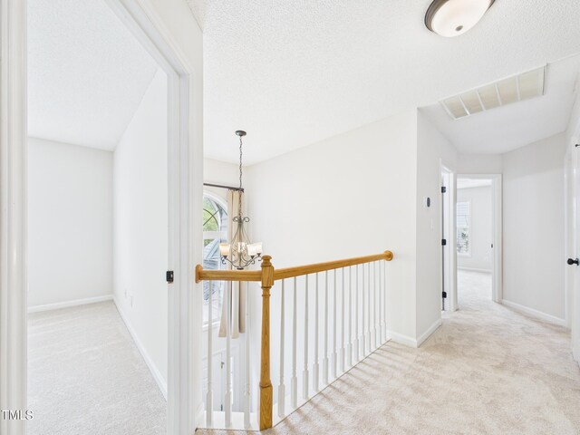 7501 Montibillo Pkwy, Durham, NC 27713 - corridor featuring carpet flooring, an upstairs landing, and a chandelier