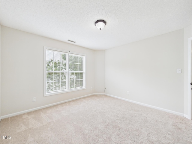7501 Montibillo Pkwy, Durham, NC 27713 - carpeted spare room featuring baseboards and a textured ceiling