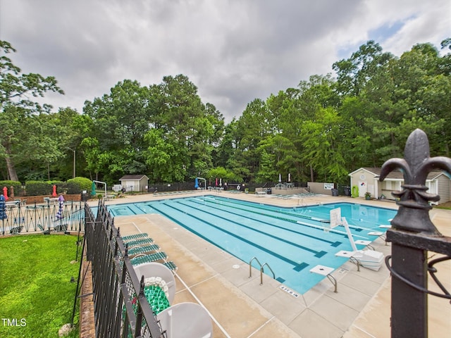 7501 Montibillo Pkwy, Durham, NC 27713 - community pool featuring view of wooded area, a patio area, and a storage shed