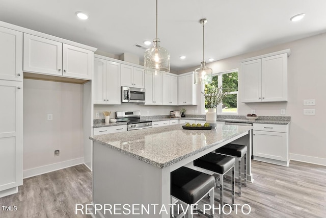 7678 New Sandy Hill Church Rd, Sims, NC 27880 - kitchen featuring appliances with stainless steel finishes, white cabinets, a kitchen island, light wood-type flooring, and recessed lighting
