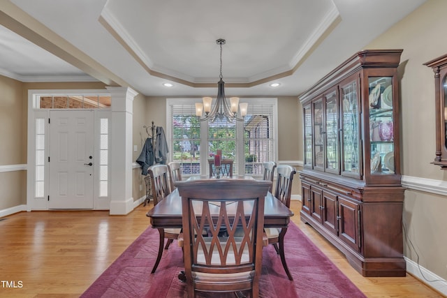 3728 Marwick Ct, Wendell, NC 27591 - dining room featuring a chandelier, a tray ceiling, crown molding, light wood-type flooring, and decorative columns