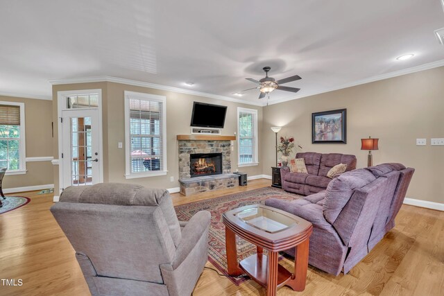 3728 Marwick Ct, Wendell, NC 27591 - living area featuring light wood-style flooring, ornamental molding, a ceiling fan, and a stone fireplace