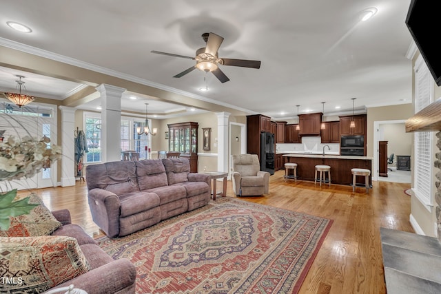 3728 Marwick Ct, Wendell, NC 27591 - living area with ornate columns, a ceiling fan, light wood finished floors, ornamental molding, and a chandelier