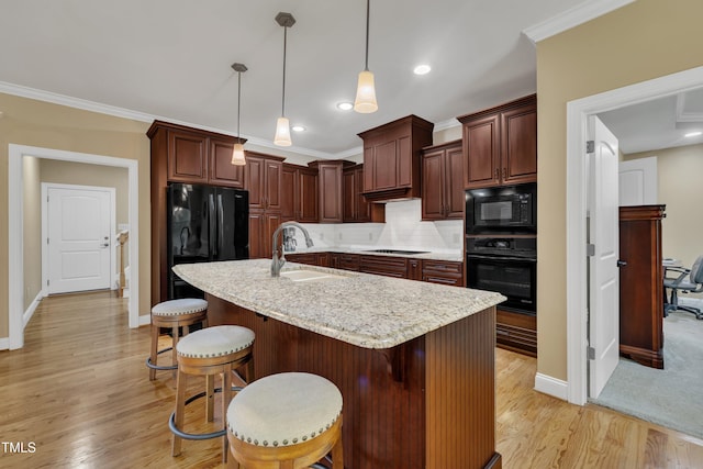 3728 Marwick Ct, Wendell, NC 27591 - kitchen featuring black appliances, tasteful backsplash, light wood-type flooring, a breakfast bar area, and hanging light fixtures