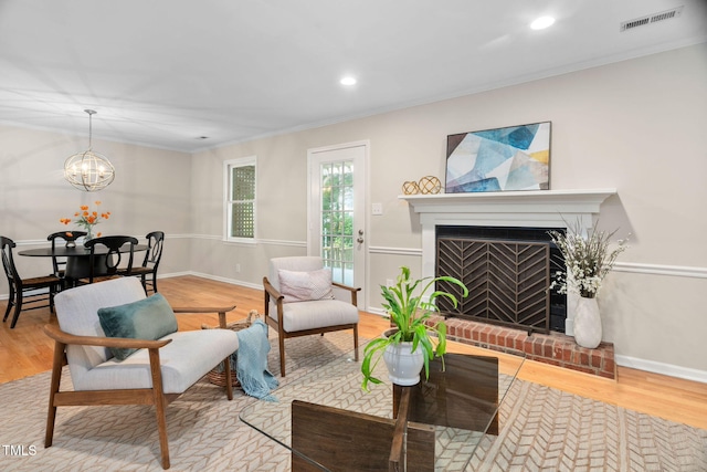 1563 Laureldale Dr, Raleigh, NC 27609 - living area with ornamental molding, wood finished floors, a fireplace, a chandelier, and recessed lighting