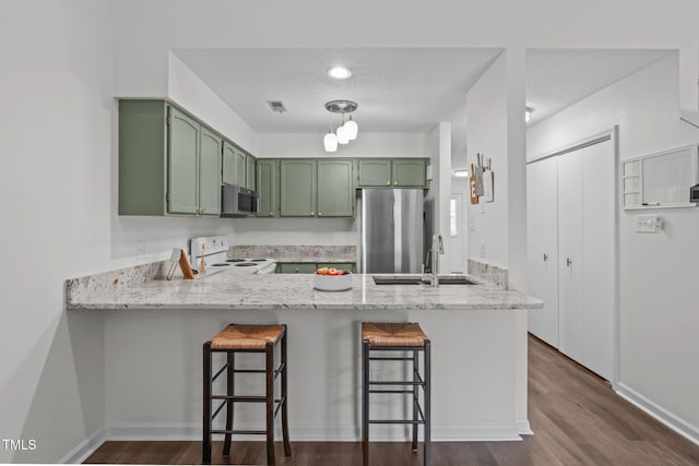 11 Stone Village Ct, Durham, NC 27704 - kitchen featuring green cabinets, appliances with stainless steel finishes, a peninsula, and dark wood-type flooring