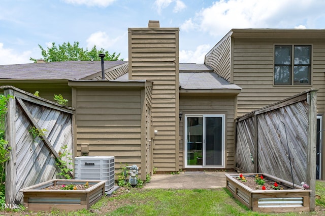11 Stone Village Ct, Durham, NC 27704 - back of house featuring a garden, a chimney, a patio area, and a shingled roof