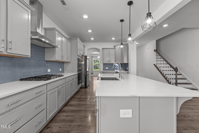 1414 Arena Ln, Fuquay Varina, NC 27526 - kitchen featuring wall chimney range hood, gray cabinets, dark wood-style floors, recessed lighting, and an island with sink