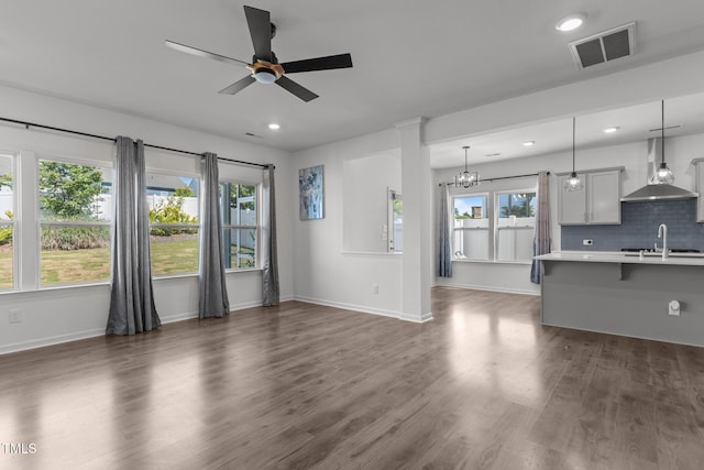 1414 Arena Ln, Fuquay Varina, NC 27526 - unfurnished living room featuring ceiling fan, a chandelier, dark wood-style floors, and recessed lighting