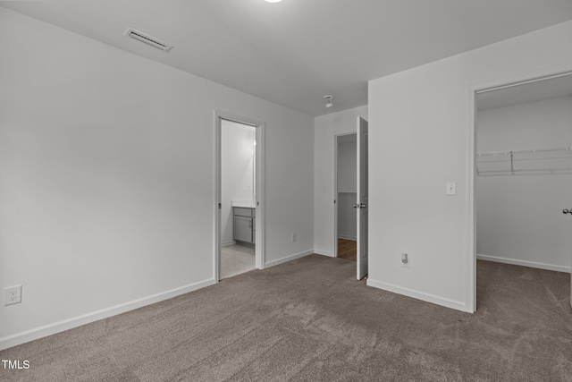 1414 Arena Ln, Fuquay Varina, NC 27526 - unfurnished bedroom featuring carpet flooring, a walk in closet, a closet, and ensuite bath
