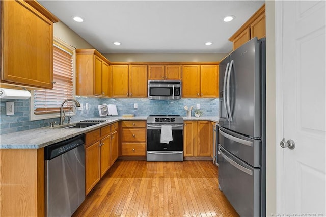 104 Somerset Dr, Raeford, NC 28376 - kitchen featuring stainless steel appliances, light wood-type flooring, brown cabinets, backsplash, and recessed lighting