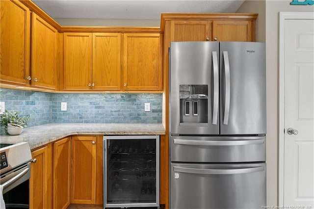104 Somerset Dr, Raeford, NC 28376 - kitchen featuring appliances with stainless steel finishes, wine cooler, tasteful backsplash, and brown cabinets