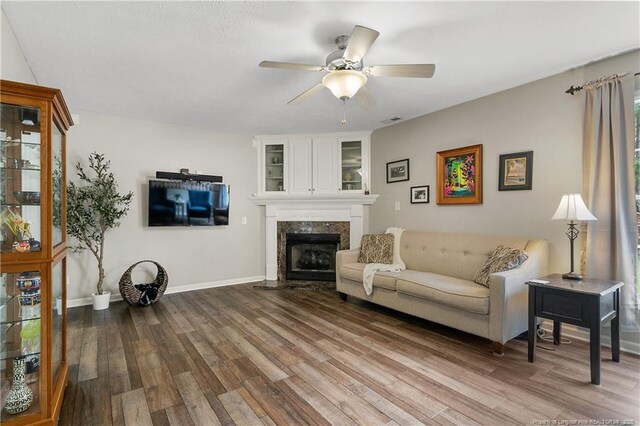 104 Somerset Dr, Raeford, NC 28376 - living room featuring wood finished floors, ceiling fan, and a premium fireplace