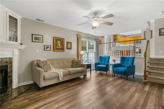 104 Somerset Dr, Raeford, NC 28376 - living room featuring wood finished floors, ceiling fan, a premium fireplace, and stairway