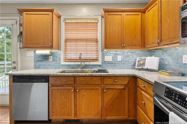 104 Somerset Dr, Raeford, NC 28376 - kitchen with stainless steel appliances, light stone counters, tasteful backsplash, and brown cabinetry