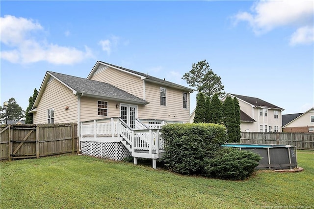 104 Somerset Dr, Raeford, NC 28376 - back of property with a wooden deck, a fenced backyard, a gate, and a shingled roof