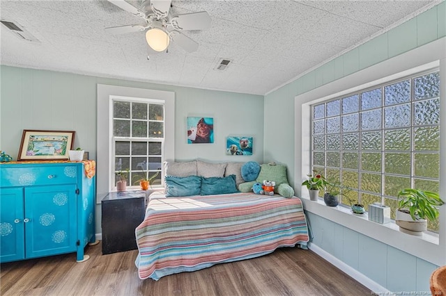 944 Cain Rd, Saint Pauls, NC 28384 - bedroom with multiple windows, wood finished floors, ceiling fan, a decorative wall, and ornamental molding