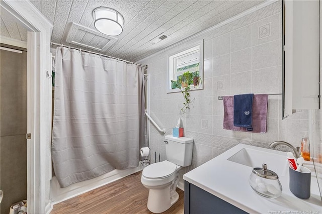 944 Cain Rd, Saint Pauls, NC 28384 - bathroom featuring tile walls, vanity, wood finished floors, and shower / bathtub combination with curtain