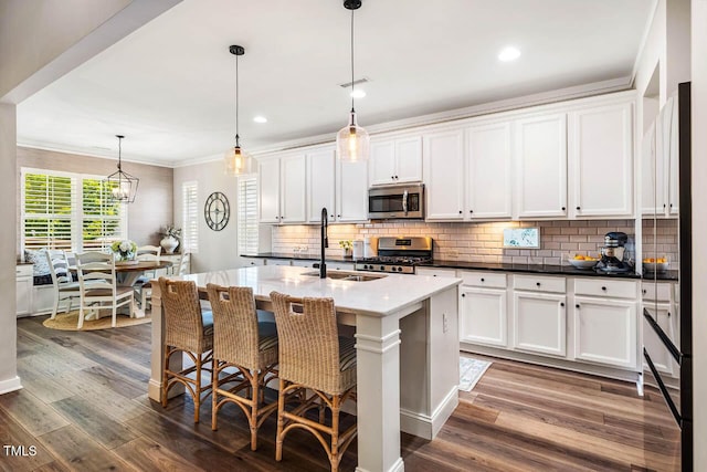 42 Juneberry Dr, Chapel Hill, NC 27516 - kitchen with stainless steel appliances, tasteful backsplash, white cabinetry, ornamental molding, and dark wood finished floors