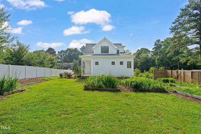 5107 Overhill St, Raleigh, NC 27603 - back of property featuring a fenced backyard, board and batten siding, and a vegetable garden