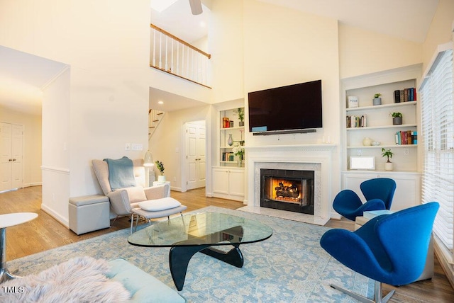 10 Marchmont Ct, Durham, NC 27705 - living room featuring stairs, light wood-style floors, a fireplace with flush hearth, built in features, and high vaulted ceiling