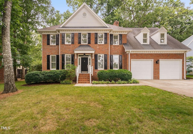 202 Stoneleigh Dr, Cary, NC 27511 - colonial house featuring concrete driveway, a garage, a front lawn, a chimney, and brick siding