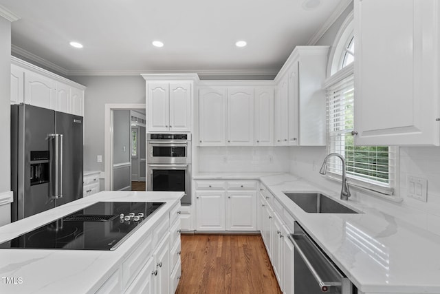 202 Stoneleigh Dr, Cary, NC 27511 - kitchen featuring appliances with stainless steel finishes, white cabinetry, crown molding, light stone countertops, and decorative backsplash