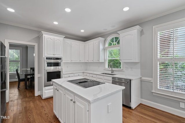 202 Stoneleigh Dr, Cary, NC 27511 - kitchen with appliances with stainless steel finishes, white cabinetry, ornamental molding, light wood-style floors, and light stone countertops