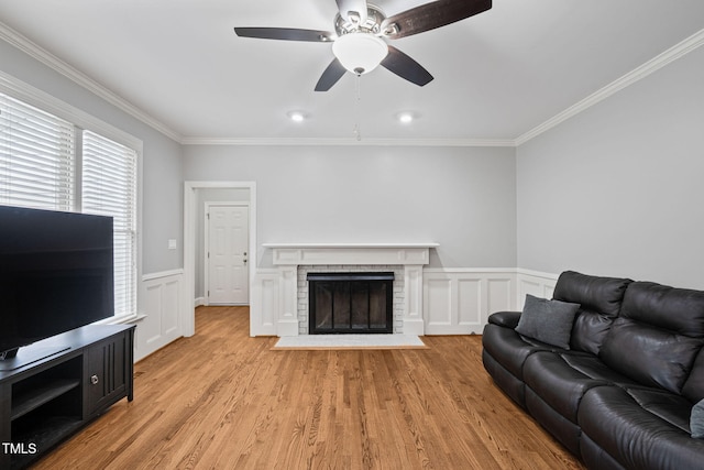 202 Stoneleigh Dr, Cary, NC 27511 - living area with crown molding, a brick fireplace, light wood-style flooring, wainscoting, and a decorative wall