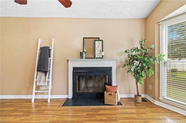 3820 Crusader Dr, Hope Mills, NC 28348 - living area featuring wood finished floors, a fireplace with flush hearth, ceiling fan, and a textured ceiling